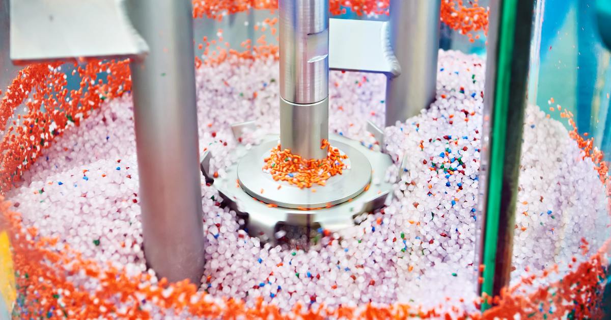 A variety of plastic granules in a centrifuge. The plastics are primarily white and orange, but other colors are mixed in.