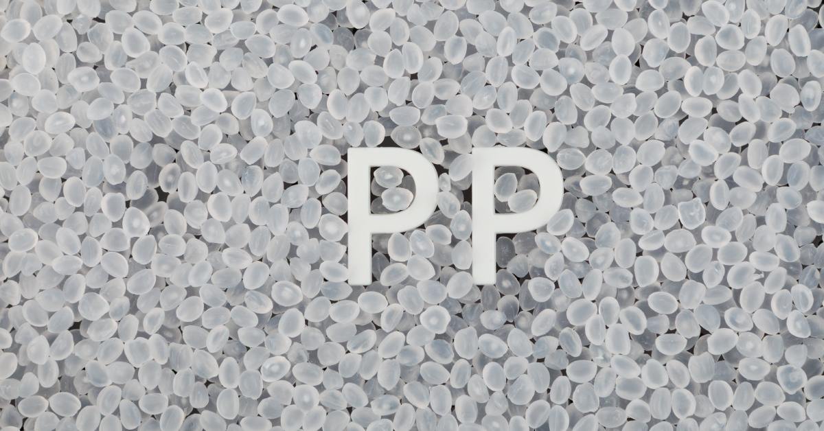 A batch of small clear polypropylene granules collected together. Two white letters, "P" and "P", sit in the granules.