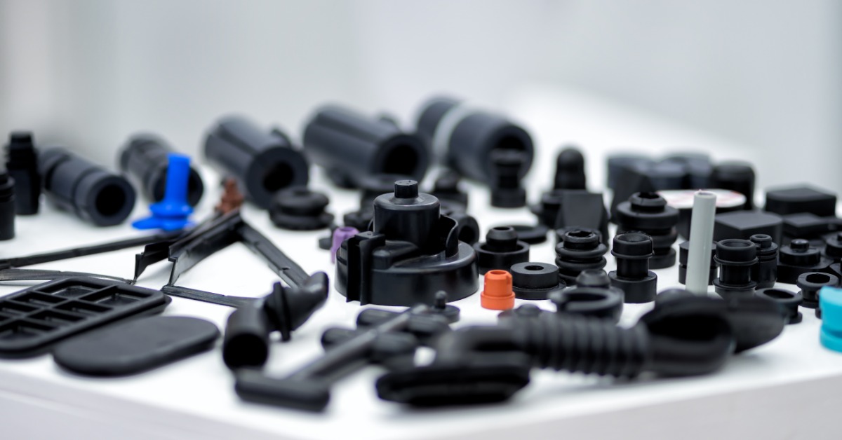 An array of plastic parts, primarily molded with black plastic, sitting on top of a white display surface.