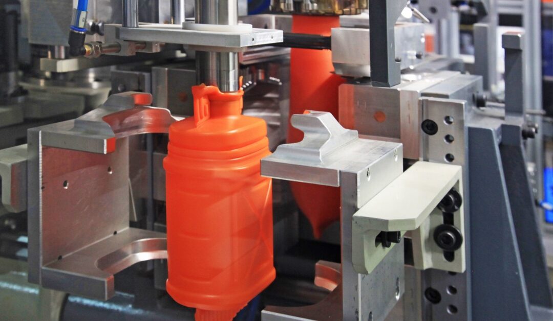 The production of bright orange hollow canisters using a form of plastic molding in a manufacturing setting.
