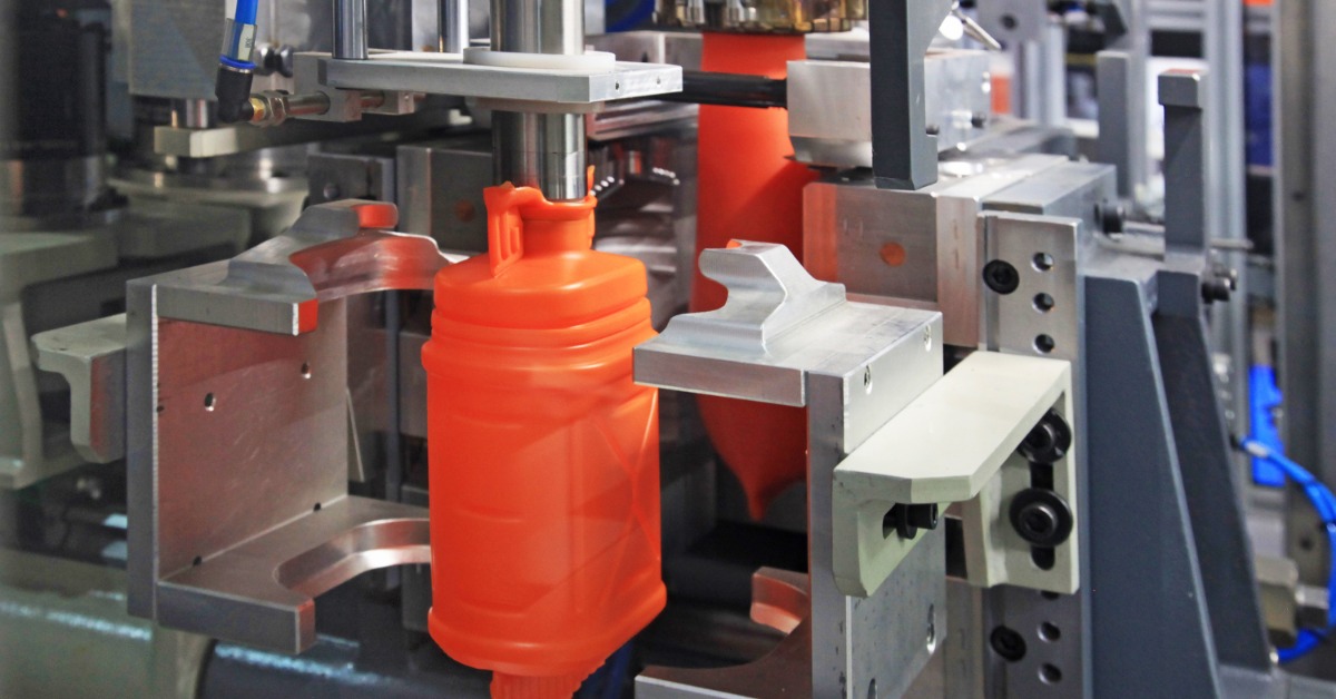 The production of bright orange hollow canisters using a form of plastic molding in a manufacturing setting.